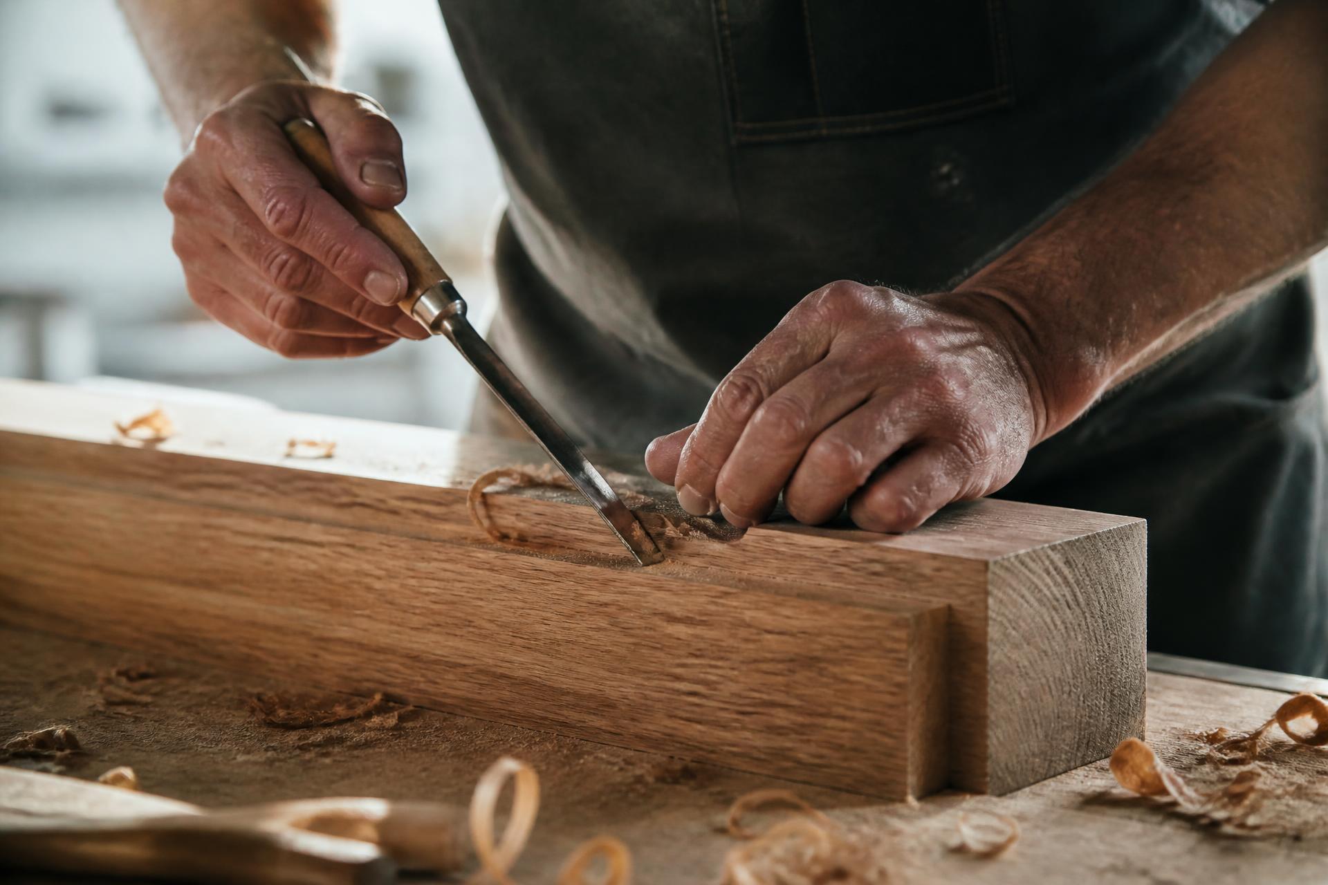 Master carpenter shaping oak timber